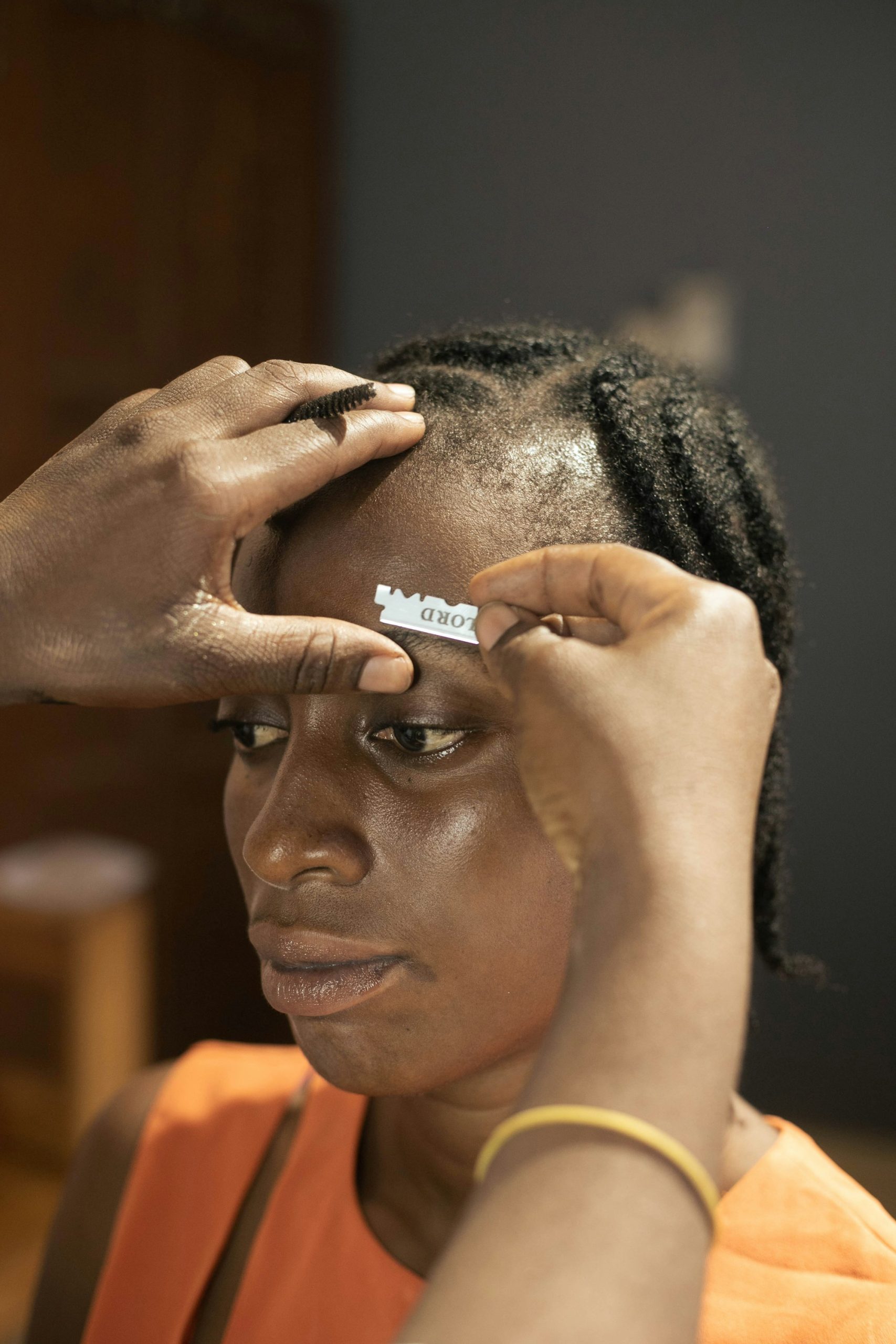 A therapist shaping a client’s eyebrows