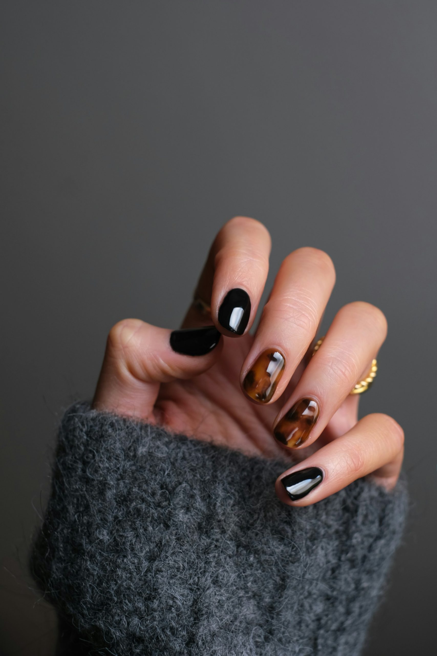Nail art with gold details and dark accents