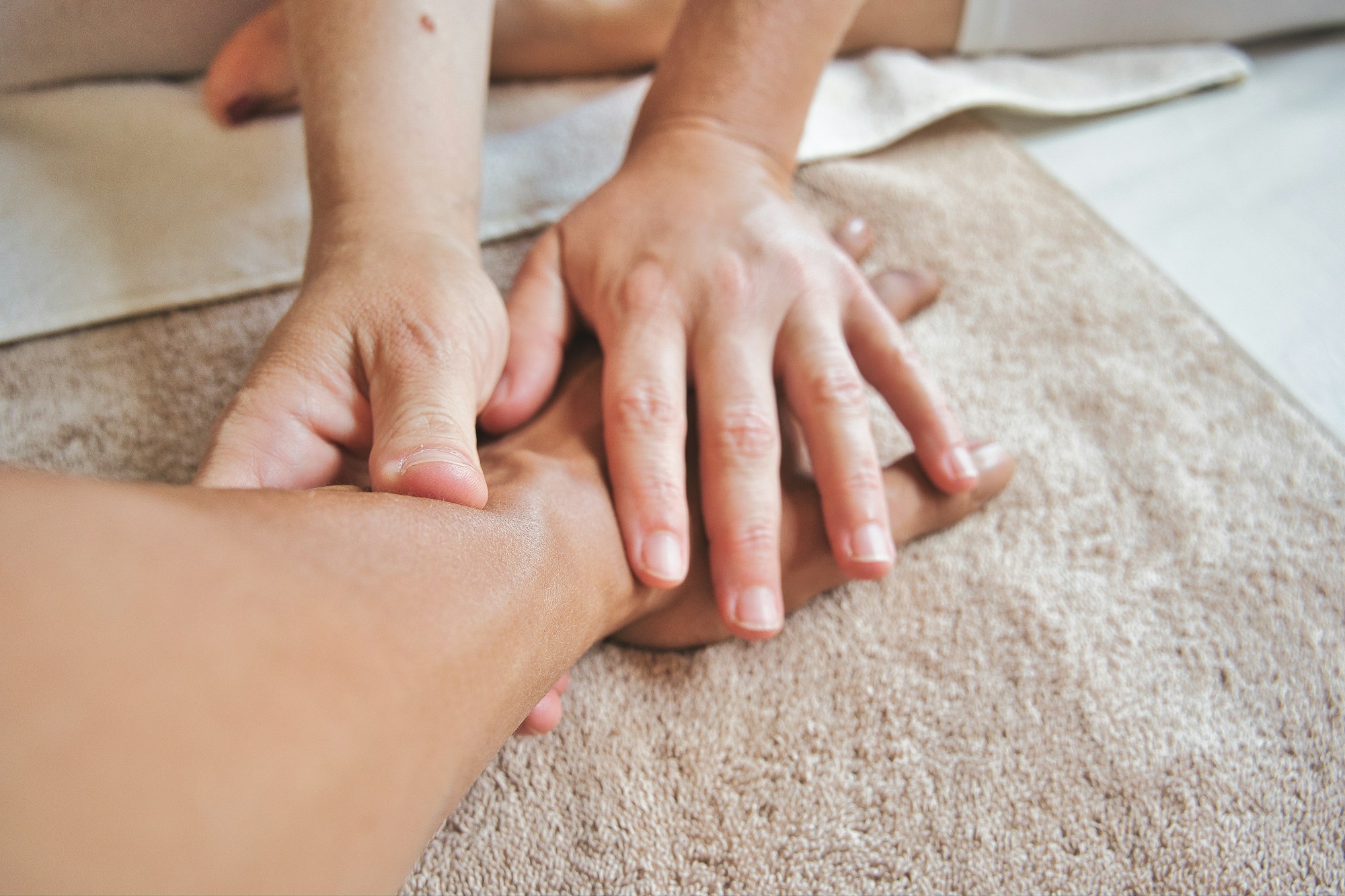 Hands resting on a soft towel during a relaxing hand massage